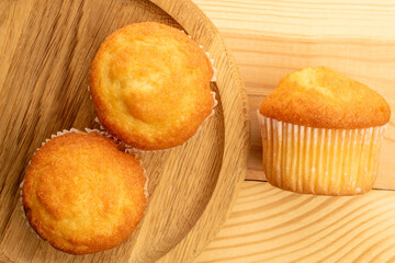 Delicious muffins  on a wooden table, top view, close-up.