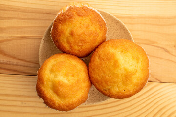 Delicious muffins  on a wooden table, top view, close-up.
