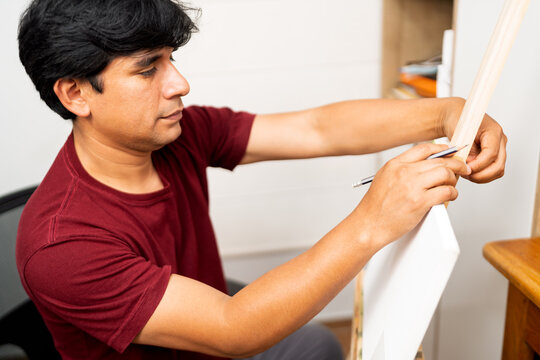Artist drawing line on canvas in studio