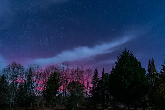 Star filled night sky illuminated by the bright magentas of the Aurora Borealis over the Dordogne region of France