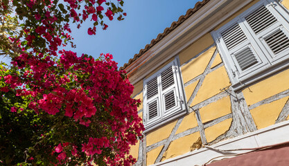 Yellow facade and red bougainvillea in one of the streets of Lefkas city.