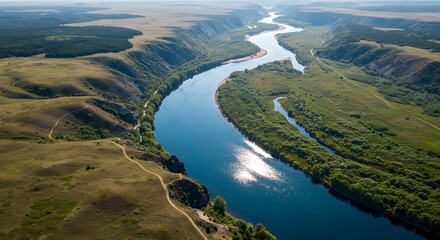 Aerial view of a serene river winding through green landscapes and hills