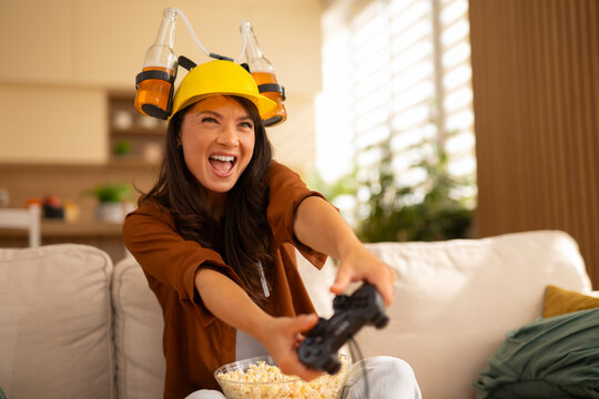 Woman wearing beer hat playing exciting video game