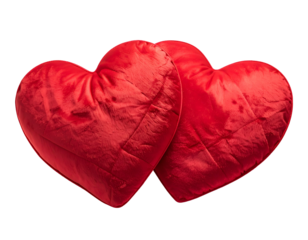 Two plush red heart-shaped pillows are nestled together