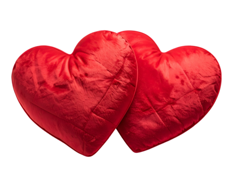 Two plush red heart-shaped pillows are nestled together