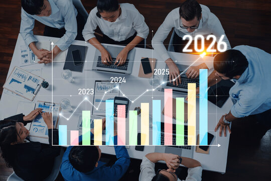 A business team collaborates in a strategic meeting, analyzing data trends and projections for 2023 to 2026 using graphs and advanced technology to make informed decisions. Trope