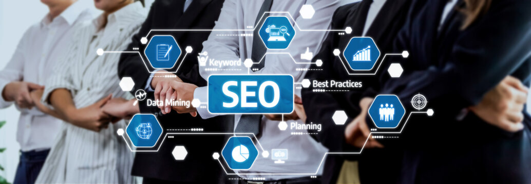 A diverse team of professionals in business attire working together on SEO strategies, showcasing data visualizations, graphs, and planning tools in a modern office environment. Amity - Powered by Adobe