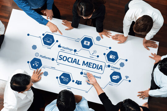 A diverse team gathers around a table discussing social media strategy, highlighting key concepts, engagement opportunities, and digital marketing tools for effective communication. Amity