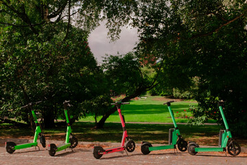 Electric scooters parked in a green city park in Helsinki