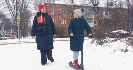 Woman and child walking on snowy street during winter season  