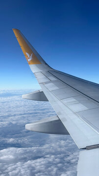 Istanbul, Turkey - October 18, 2025: Airplane wing above clouds with Sabiha Gokcen Airport branding