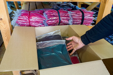 Textile industry. Packing of knitwear in cardboard boxes. Clothing warehouse.