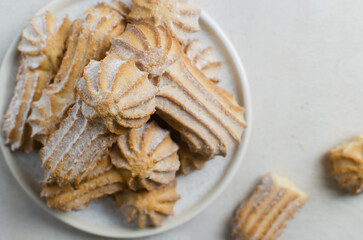 Tasty shortbread cookies with beautiful edges and powdered sugar on a gray background. Coffee time concept. Selective focus. Horizontal orientation. Top view. Copy space