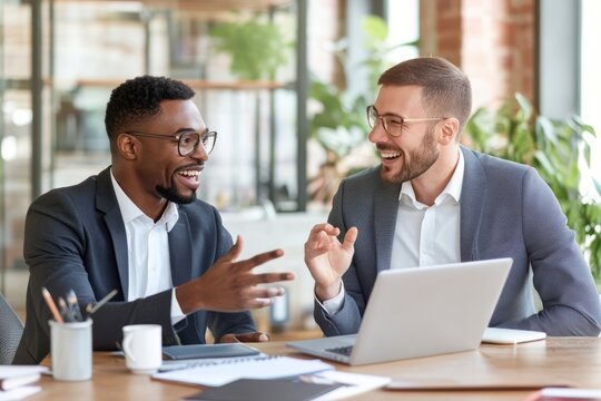 Two professionals sharing ideas during a business meeting, analyzing data on a computer screen. High-quality teamwork and leadership image.