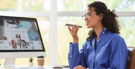 Young African-American businesswoman using mobile phone in office