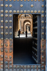 Open doors reveal sunlit courtyard at University of Seville