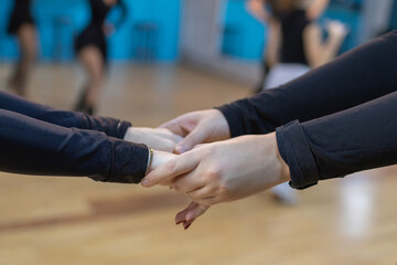 students holding hands in dancing during class in a bright studio