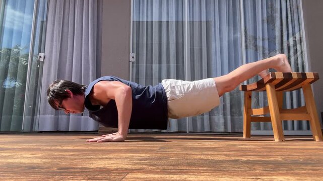 homem treina faz exerc&iacute;cios f&iacute;sicos em casa 