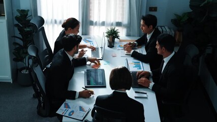 Top view of business people working together to analysis stock market data while sitting at meeting table with financial statistic graph. Project manager planning strategy by using laptop. Directorate - Powered by Adobe