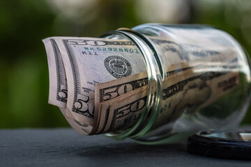 US dollar banknote saving money in glass jar. Consumption and economy