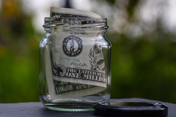 Million dollar banknote saving money in glass jar. Consumption and economy