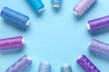 Frame made of thread spools on blue background