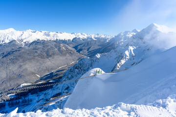 A view of snowy peaks with a sunbeam on the horizon.