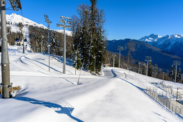 Snowy mountains and resort infrastructure against the bright sunny sky.