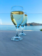 two glasses of cretan wine on Agia Marina beach, Crete Greece, toned