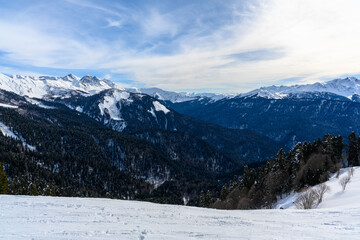 Panoramic view of the highlands, valley, forest and snowy slopes.