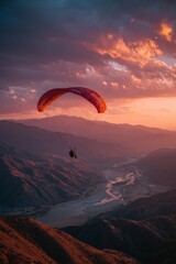 Paragliding Over Mountains at Sunset With a River Winding Below