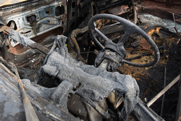 The charred interior of a car completely destroyed by fire. Melted dashboard and burnt seats show the devastating aftermath of a vehicle fire. Isolated on a white background.