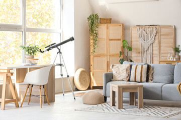 Interior of living room with telescope, sofa and workplace