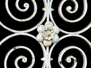 White ornamental wrought iron door with ornamental iron flower