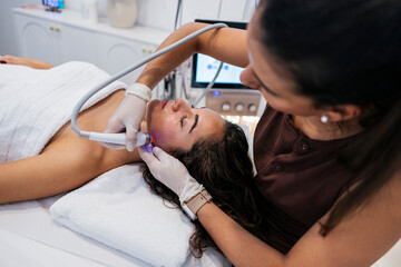 Woman receiving modern facial treatment for skincare and beauty