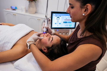Woman receiving advanced facial skincare treatment at beauty salon