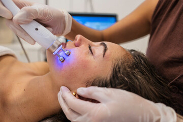 Woman receiving microcurrent facial treatment for skin rejuvenation
