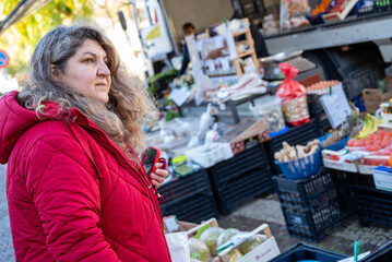 Woman shopping for fresh produce at outdoor street market