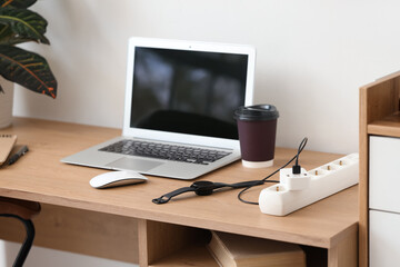 Extension cord with charging smartwatch on desk in office