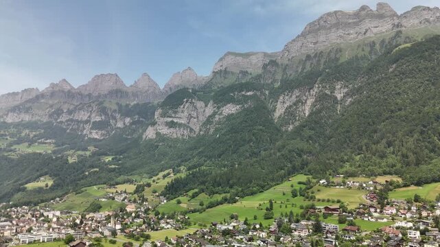 Aerial Drone View of the Swiss Alpine Valley with Green Fields, Rolling Hills, and Majestic Mountains near Flums, Berschis, and Walenstadt in the Canton of St. Gallen, Switzerland