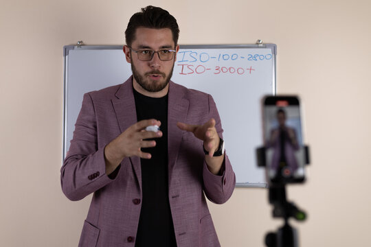 The man is recording a video for his blog using a smartphone - Powered by Adobe