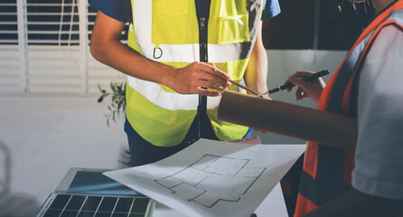 Closeup of team of industrial engineers meeting analyze machinery blueprints consult project on...