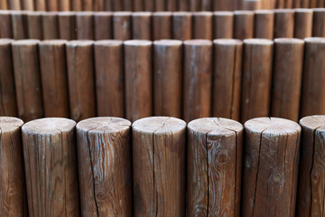 a row of identical wooden pillars with cracks along them
