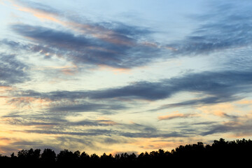 The sky is filled with clouds and the sun is setting