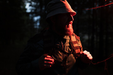 Naklejka premium A man with a beard and a hat is walking in the woods