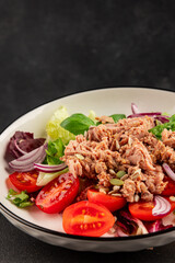 Tuna salad canned fish, tomato, green leaf salad vegetable dish tasty snack fresh gourmet food background on the table rustic top view copy space keto and paleo diet vegetarian food pescetarian diet