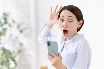 驚く女性　スマホ