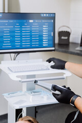 Dentist using intraoral scanner with patient records on screen, digital dental exam