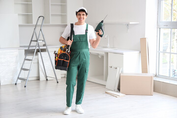 Male worker with tool bag assembling furniture in kitchen