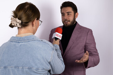 A journalist is interviewing a man with a microphone